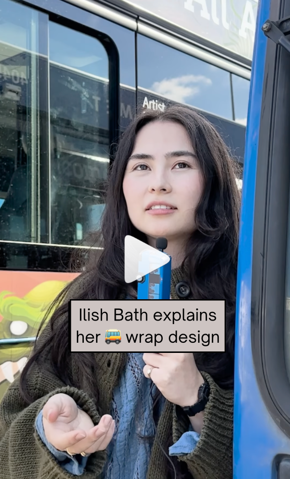 Artist stands next to bus design