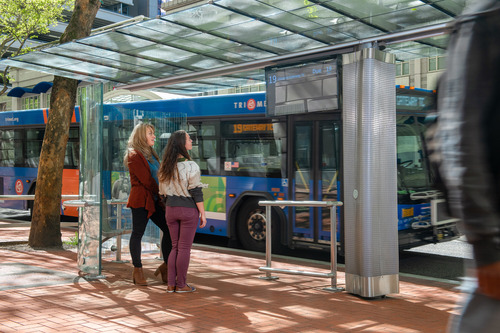 Riders check out a digital display at a MAX station