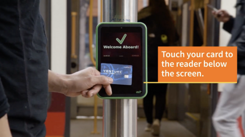 Person tapping their credit card on a Hop reader