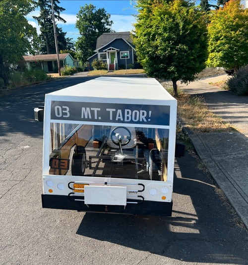 Soap box bus with a "Mt. Tabor" sign sitting in front of a house
