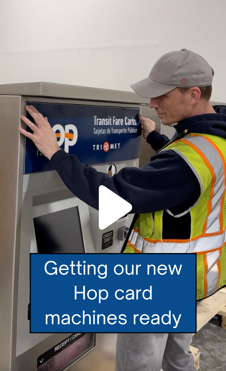 Man holding up decal to put on a Hop card machine