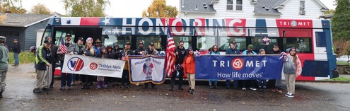 Members of TriMet's Veterans Employee Resource Group stand in front of the Vets bus, following the Portland Veterans Day parade