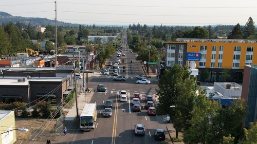 Image of the intersection of Southeast 82nd Avenue and Division Street in Portland, with a TriMet Line 72 bus in the foreground.