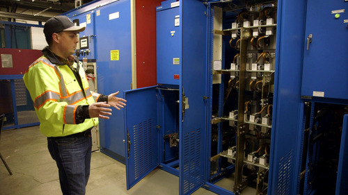 Image of a TriMet employee wearing a safety vest next to substation equipment