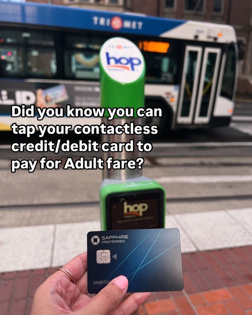 Person tapping a credit card on a Hop reader at a platform