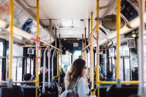 Image of the interior of a TriMet bus, with riders both sitting and standing.