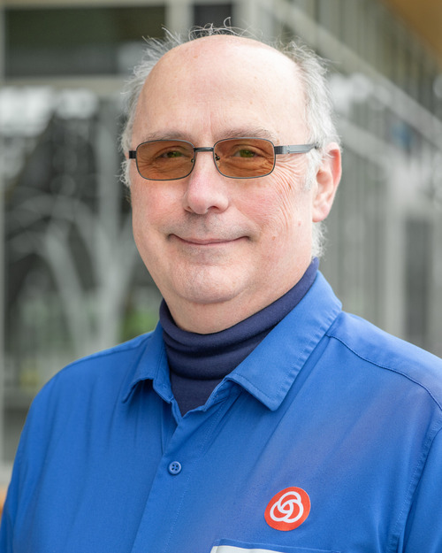 Portrait of TriMet Bus Operator Joe Wiggins, a man with white hair and glasses.