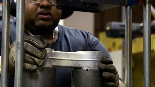 Image of TriMet Light Rail Vehicle Technician Joe Ruffin working with machinery.