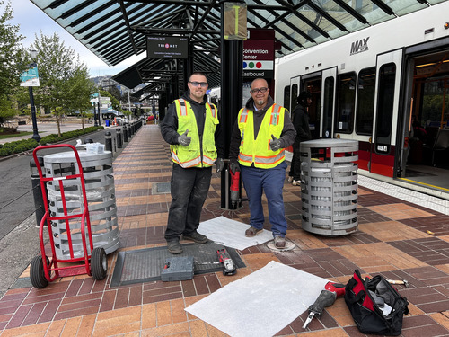 Image of two men on the TriMet Clean Team posing with thumbs up at the Convention Center MAX Station.