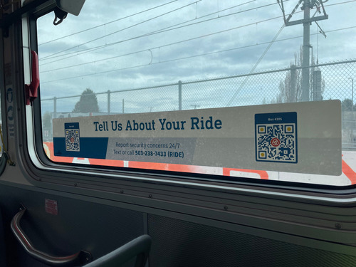 Image of a decal and QR code on a TriMet bus window reading: "Tell Us About Your Ride."