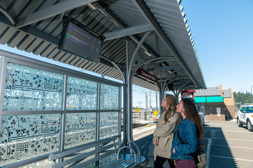Image of two women looking at a digital display at the Gateway/NE 99th Ave Transit Center in Portland.