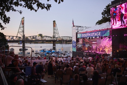 Image of a crowd at the South Stage of the Waterfront Blues Festival, with the Willamette River and Hawthorne Bridge in the background.
