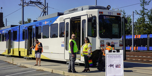 Image of TriMet MAX car 101 on a maintenance track, with several people in safety vests in front of it