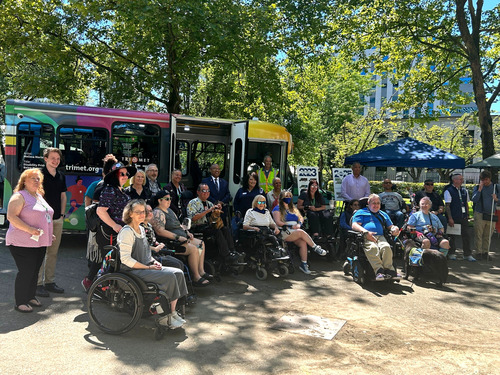 Image of a group of people, many of them in wheelchairs, posing for a picture in front of a TriMet LIFT bus