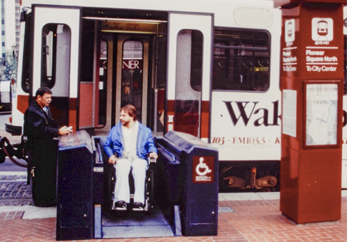 A person using a wheelchair boarding a Type 1 train via an accessibility lift