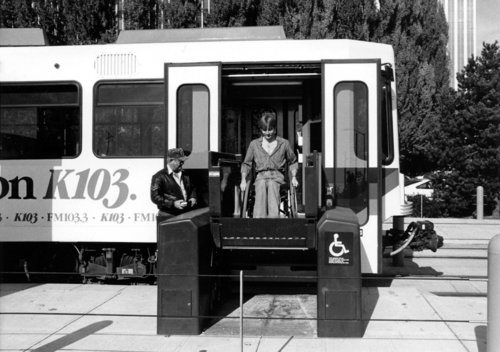 A person using a wheelchair boarding a public transit vehicle via an accessibility lift