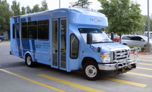 TriMet NEXT vehicle with a baby blue livery and dark blue stripes