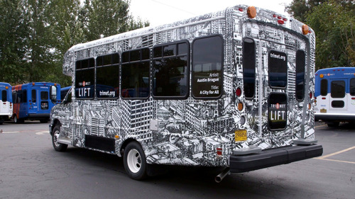 Image of a TriMet LIFT bus with an artistic depiction of the city of Portland: "A City for All" by artist Austin Brague