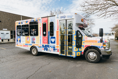 Image of a TriMet LIFT bus with a colorful artistic display and the words "Siempre Pa' Lante," by artist David DaCosta