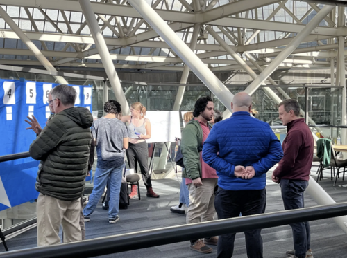 Several people talking at a service cuts open house