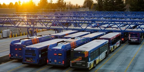 TriMet buses parked at the Powell Operations Facility in Southeast Portland as the sun sets
