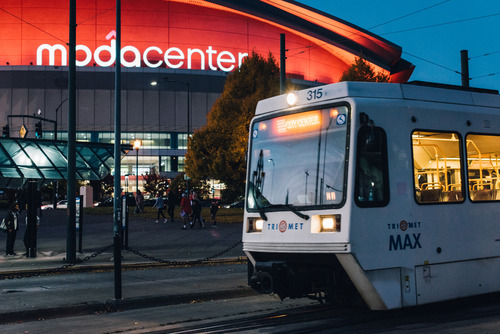 A TriMet MAX train passes in front of the Moda Center in Northeast Portland after dark