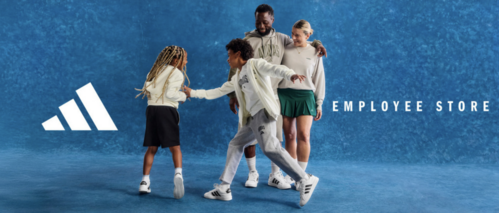 A family of four wearing coordinated Adidas outfits stands against a textured blue backdrop, smiling and playfully interacting