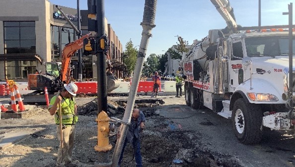 Crews use a vac truck to remove water and other debris from underground trench.