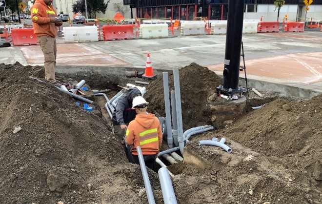Crews installing conduit in a trench