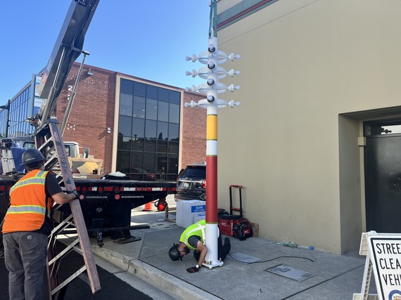 An 1960s light post refurbished art piece being installed