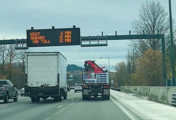Vehicles driving on SR167 with an electronic readerboard giving estimated times for Kent and Auburn