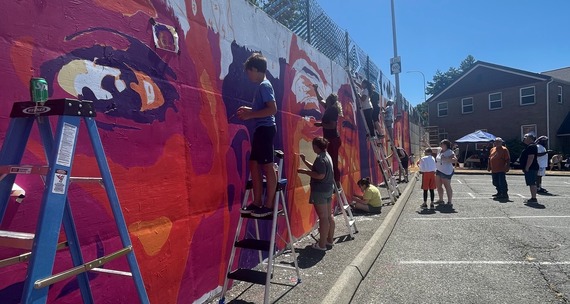 Many community members of all ages painting the Sunset Community Mural