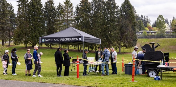 A line waiting for food at the park during a Neighborhood Program BBQ event