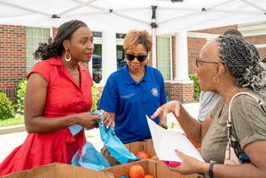 Councilmembers Chakisse Newton, District 11, and Gretchen Cooper, District 7, pass out food.