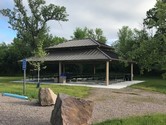 picnic shelter with large rock by walking path