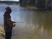 man with a fishing rod standing by a body of water
