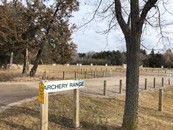 Archery Range sign with archery targets in the background