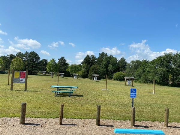 picnic table in the grass with archery targets in background