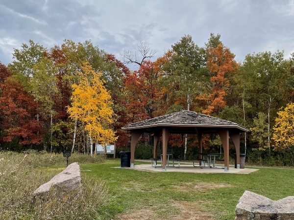 picnic shelter with fall colored trees in background