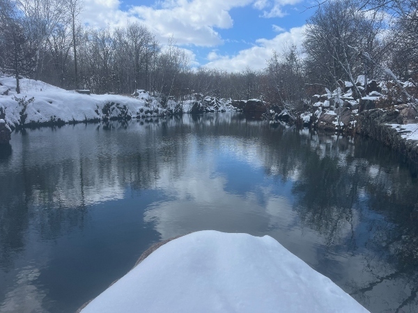 open water in a quarry surrounded by snow