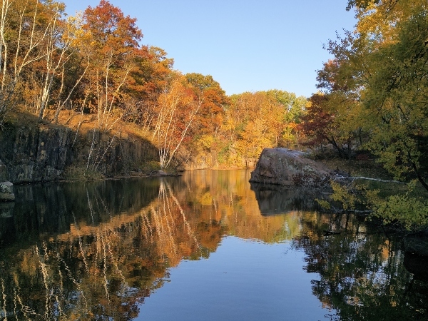 water in a quarry surrounded by fall colored trees