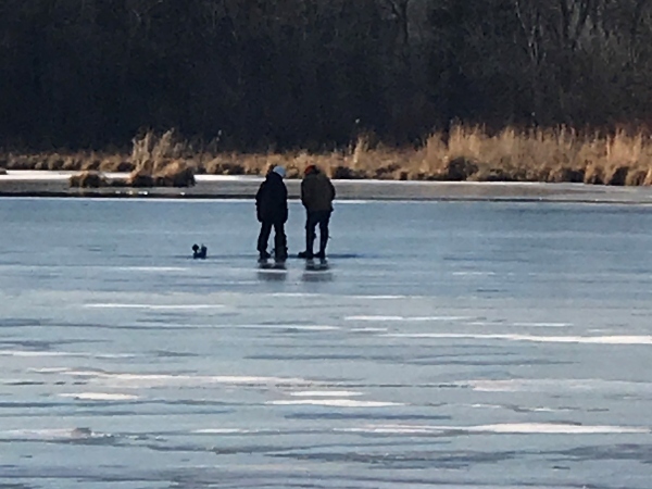 two people ice fishing on a frozen lake