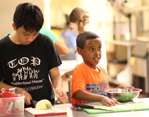 Child learning to cook at El Rio Vista.