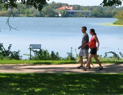 Park visitors walk around the lake