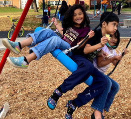 Three children on a swing at Western Sculpture Park