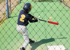 Youth swinging a bat in a batting cage