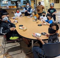 Rec Check youth with masks on around a table at El Rio VIsta Rec Center. 