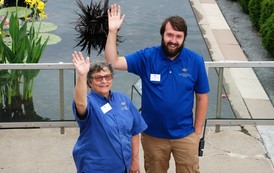 Staff outside Como Park Conservatory waving. 