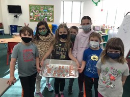 Youth wearing masks and showing off a craft project