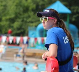 Lifeguard in a blue shirt and sunglasses at Highland Park Aquatic Center. 